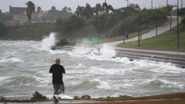 walks near the bay waters as they churn from approaching Hurricane Harvey on August 25, 2017 in Corpus Christi, Texas