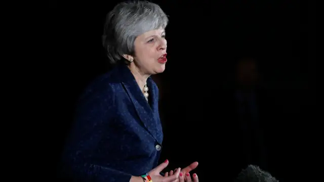 Theresa May gesticula enquanto discursa durante a noite