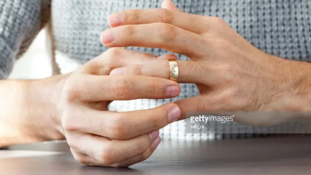 एक पुरुष बोटातली अंगठी काढताना