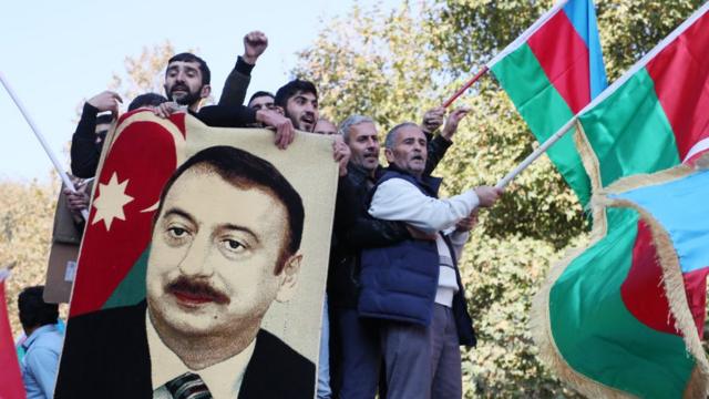 Gente con banderas azerbaiyanas celebrando el fin del conflicto