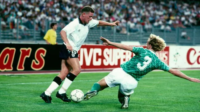 آندریاس برمه در حال تکل زدن روی پای پل گاسکوئین، هافبک تیم ملی انگلیس، در نیمه‌نهایی جام جهانی ۱۹۹۰