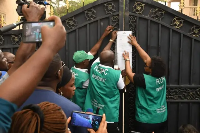 FCCPC men dey paste summon notice for Chinese supermarket gate