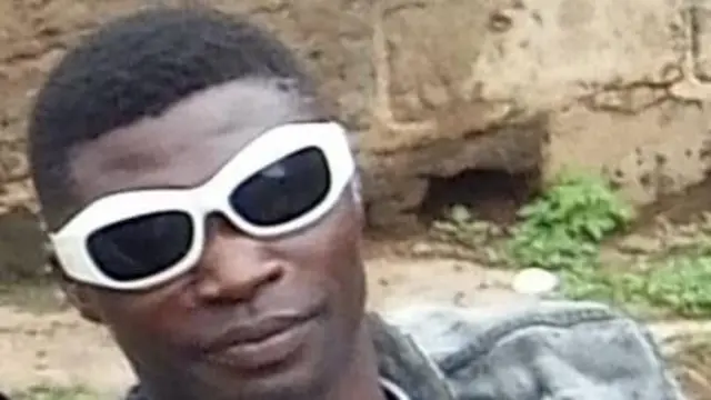 Aworan Abdullahi Saidi ti wọn lo pa Chukwuemeka, o logo dudu ti ara rẹ funfun, irun ori rẹ si pọ.