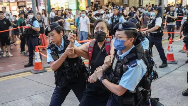 2023年6月4日，“六四事件”34周年，社民连主席陈宝莹手持黄花，在铜锣湾街头被警方带走。