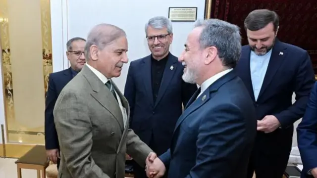 Şerif solda, Arakçi sağda karşılıklı el ele tutuşmuş gülümsüyorlar. 