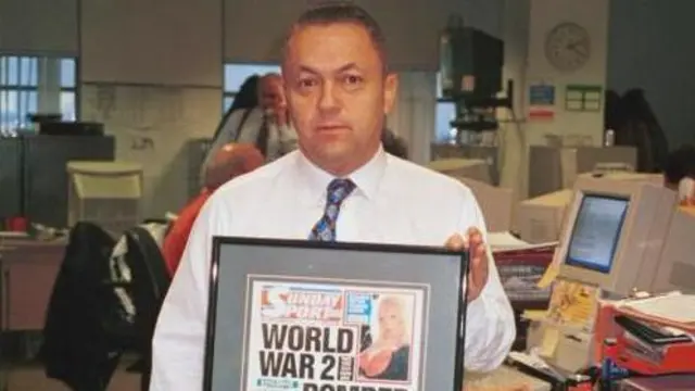 Dejvid Salivan, fotografisan 1999. godine za epizodu emisije „Back to the Floor“ na BBC Two, u košulji sa dugim rukavima i kravatom, drži uramljenu naslovnu stranu nedeljnog sporta sa plavom manekenkom u gornjem desnom uglu i naslovom: „Bombarder iz Drugog svetskog rata pronađen na Mesecu“.