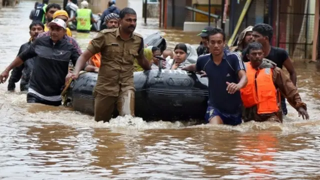 बाढ़ पीड़ितों को बाहर निकालते राहतकर्मी