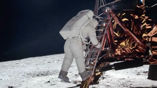 O piloto Buzz Aldrin desce os degraus da escada do módulo lunar enquanto se prepara para andar na Lua durante a missão Apollo 11