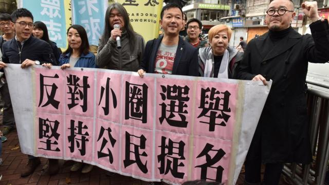 Lawmakers Nathan Law (L), Lau Siu-lai (2nd L), Leung Kwok-hung (3rd L) also known as 'Long Hair', Raymond Chan (3rd R) and Shiu Ka-chun (R) protest outside the venue of the Hong Kong chief executive election in Hong Kong on March 26, 2017.