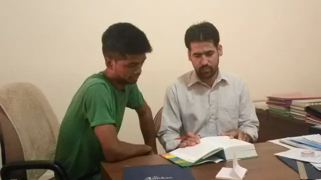 আহমেদীয়া সেন্টারে বসে কমিউনিটির নানা কাজকর্ম দেখছেন শফির ভাট ও অন্য কর্মীরা