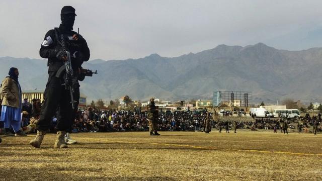 阿富汗帕尔旺省恰里卡尔市一场公开体罚大会上一名塔利班战斗人员持枪站岗（8/12/2022）