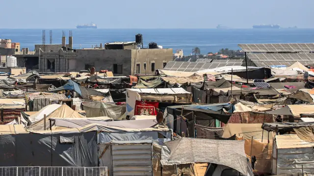 خيام نازحين فلسطينيين في رفح ويظهر خلفها منظر عام للبحر الأبيض المتوسط 