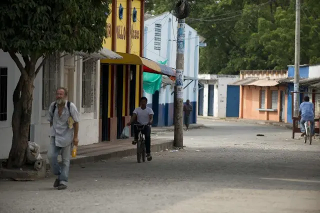 Personas caminando y montando bicicleta por una calle
