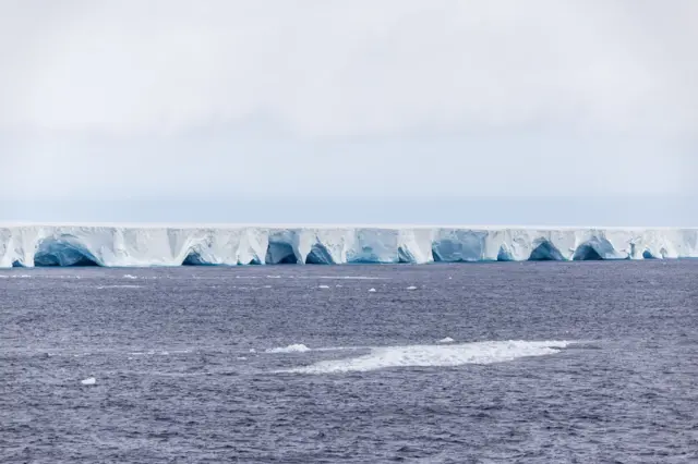 Uma foto mostrando as laterais do iceberg com arcos e cavernas