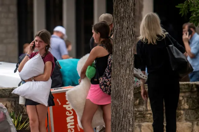 Niñas rescatadas de las inundaciones en Texas, una de ellas llora mientras habla por teléfono
