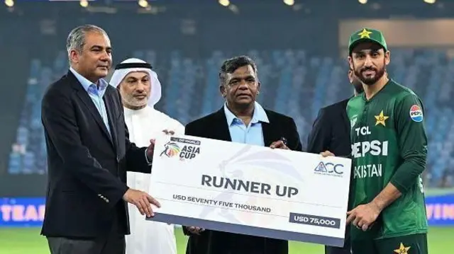 பாகிஸ்தான் கேப்டன் சல்மான் ஆகாவிடம் மொஹ்சின் நக்வி ஒரு காசோலையை வழங்குகிறார்.