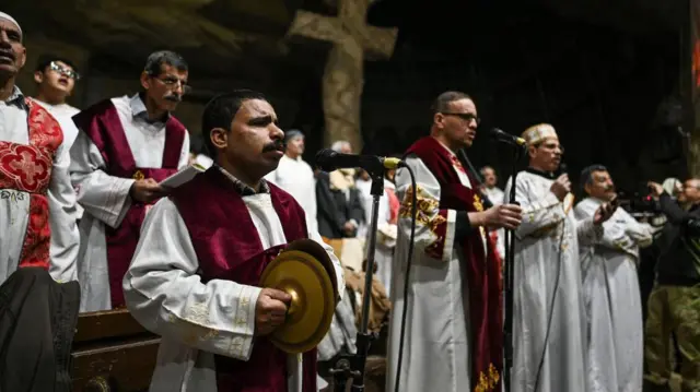 Неколико мушкараца на бини у свештеничкој одећи