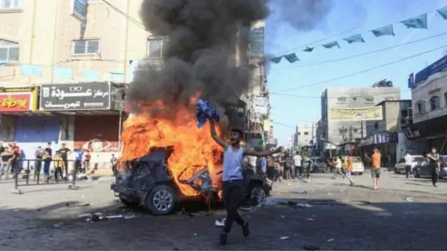 One man stand in front of burning car