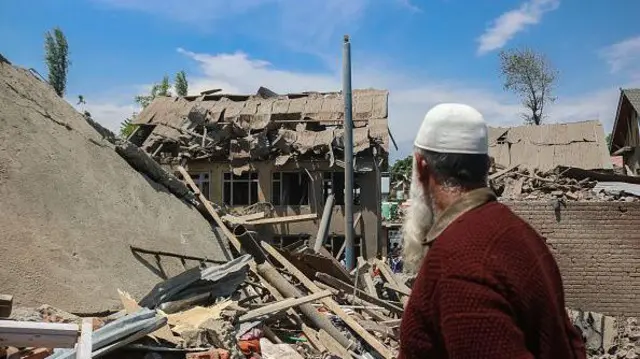 A man stands near the debris of a demolished house related to the family of Ahsan Ul Haq Sheikh, a militant who officials say is involved in the deadly attack on tourists in Pahalgam, at Murran village in Pulwama, south of Srinagar, Jammu And Kashmir, on April 26, 2025