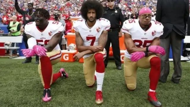 ኮሊን ካፐርኒክ (ኣብ ማእከል) ምስ ክልተ ብጾቱ ብ 2016 - ሃገራዊ መዝሙር እናተዘመረ