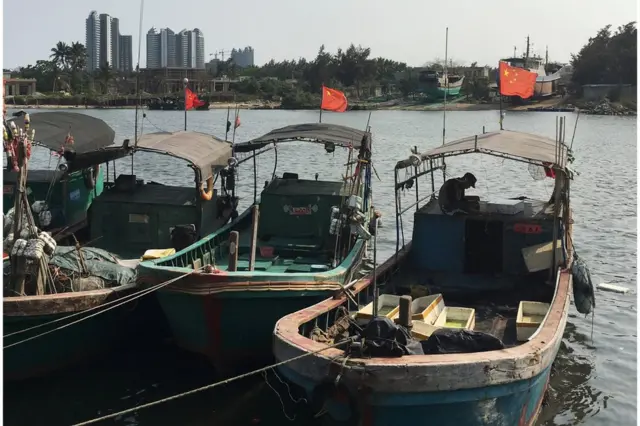 Barcos pesqueros con la bandera roja de China en el muelle de Baimajing, provincia de Hainan.