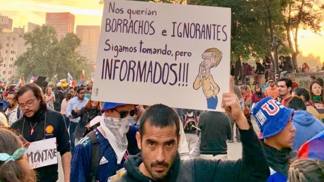 Un hombre sostiene un cartel
