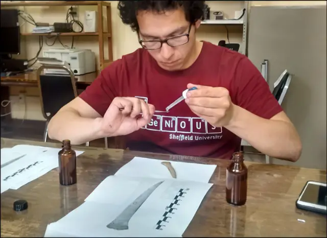 Israel Elizalde Mendez haciendo trabajos de investigación de restos óseos en una mesa