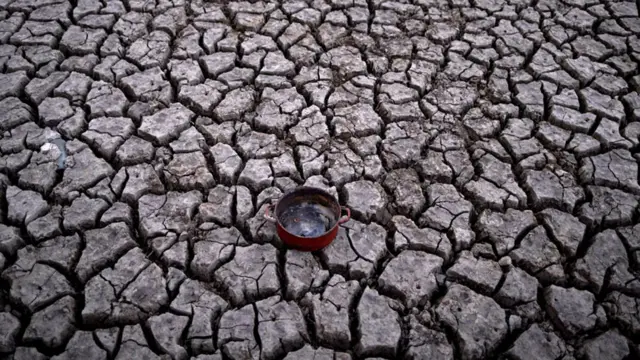 Una olla de cocina sobre tierra seca resquebrajada