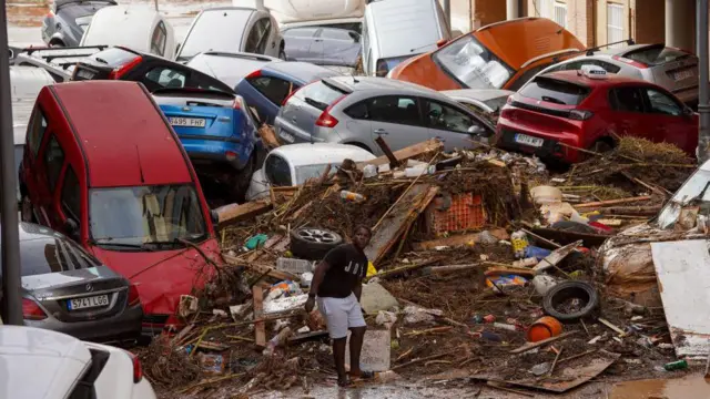 Jovemcomo fazer apostas certas no futebolfrente a entulhos e a carros arrastados por enchente amontoadoscomo fazer apostas certas no futeboluma rua