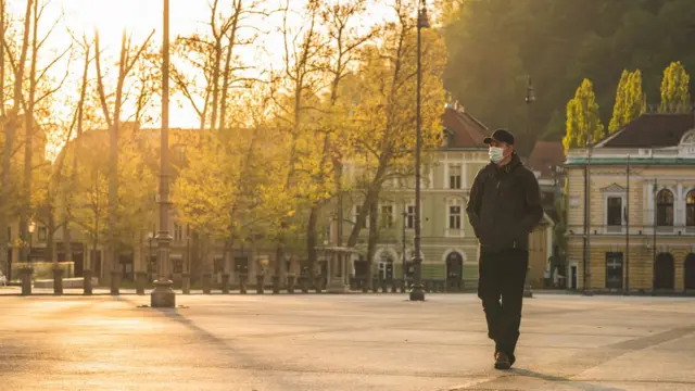 Homme avec un masque marchant dans une ville inoccupée