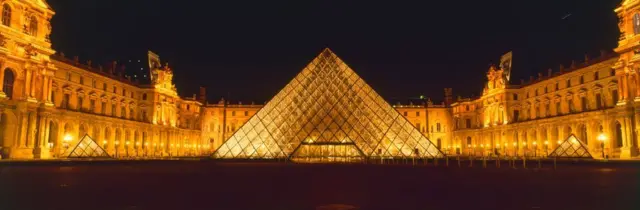 Una panorámica del Museo del Louvre y su pirámide central de cristal, con su iluminación en la noche