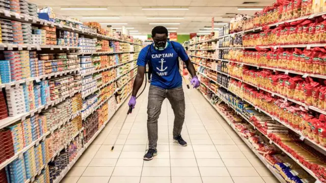 Wani mutum a wani kanti da akai wa feshin magani a Dakar a ranar 11 ga watan Mayu 2020. yayin da aka ba da umarnin rufe shaguna na wasu ranaku domin yi musu feshin dakile yaduwar cutar korona.