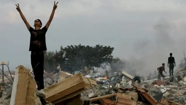 Palestinian stands on rubble of a demolished settlement building in Gaza (12/09/05)