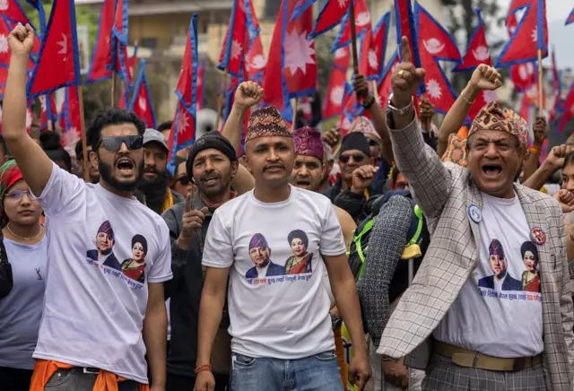 पूर्वराजा र रानीको तस्बिर भएको लुगा लगाएका समर्थकहरू