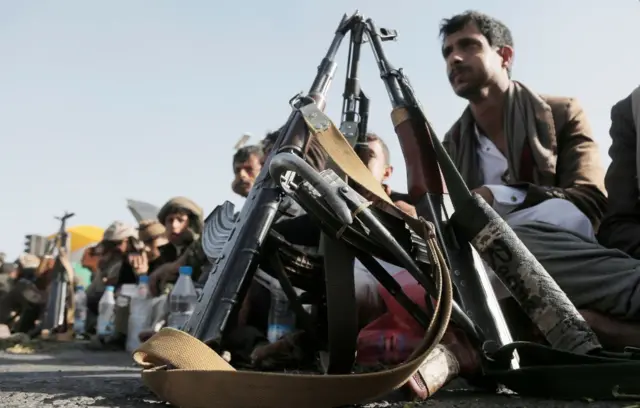 أنصار الحوثي يجلسون بجوار أسلحتهم في انتظار المشاركة في احتجاج ضد إسرائيل والولايات المتحدة والمملكة المتحدة في 3 يناير- كانون الثاني 2025 في صنعاء باليمن.