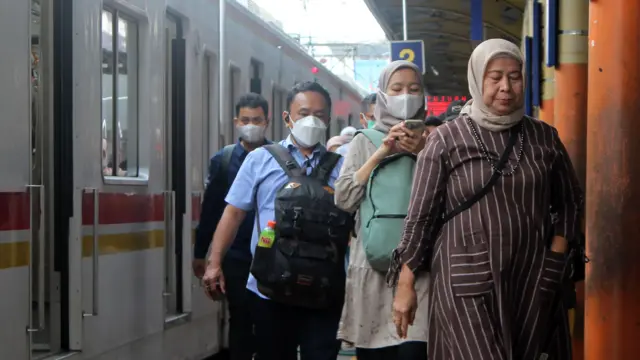 Sejumlah warga yang mengenakan masker berjalan setibanya di Stasiun Karet, Jakarta, Rabu (6/12).
