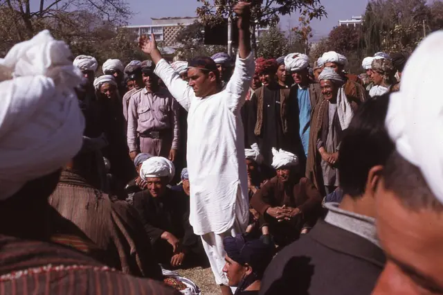 عکس گروهی از سربازان افغان در مرخصی در حال تماشای اجرایی در پارک زرنگار، کابل، افغانستان، نوامبر ۱۹۷۳. 
