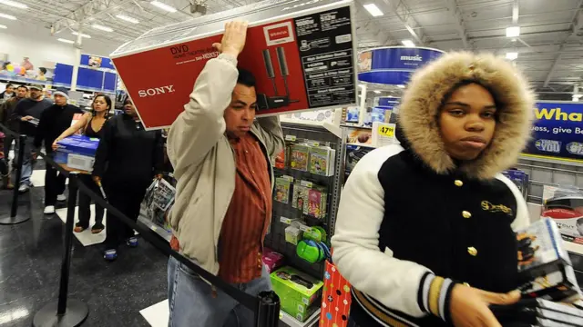 Personas cargan productos en un Black Friday.