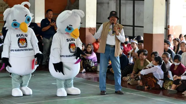Anggota KPU Kabupaten Badung bersama maskot Pemilu 2024 Sura dan Sulu memberikan informasi terkait tahapan Pemilu 2024 kepada sejumlah pelajar di Badung, Bali, Senin (14/8/2023).