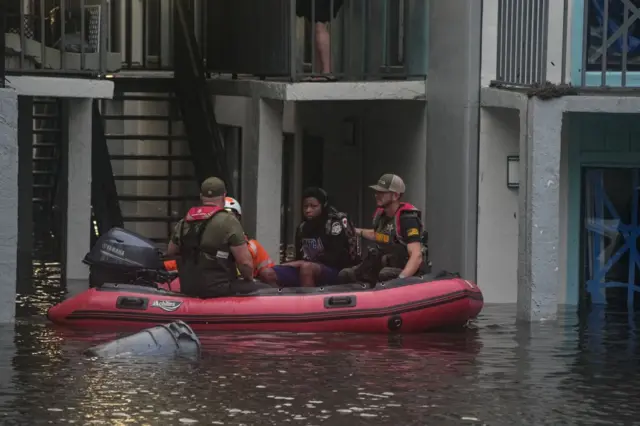 Rescatistas en una balsa socorren a una persona.