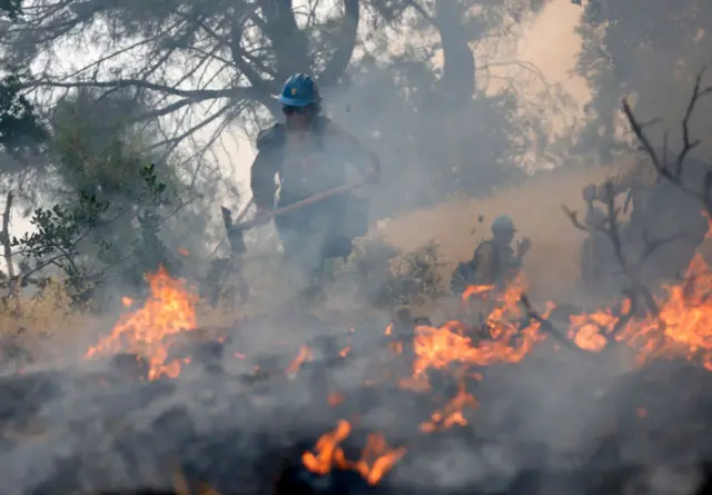 آتش نشانی در حال خاموش کردن آتش در مراتع کالیفرنیا