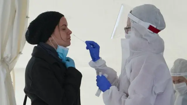 إحدى أفراد فريق طبي تأخذ عينة لإجراء فحص كورونا