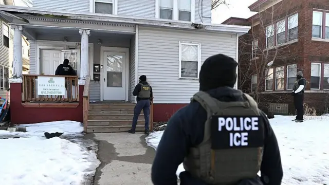 Агенти ICE підходять до будинку перед затриманням двох людей - на вулиці видно сніг, офіцери стоять по периметру подвір'я