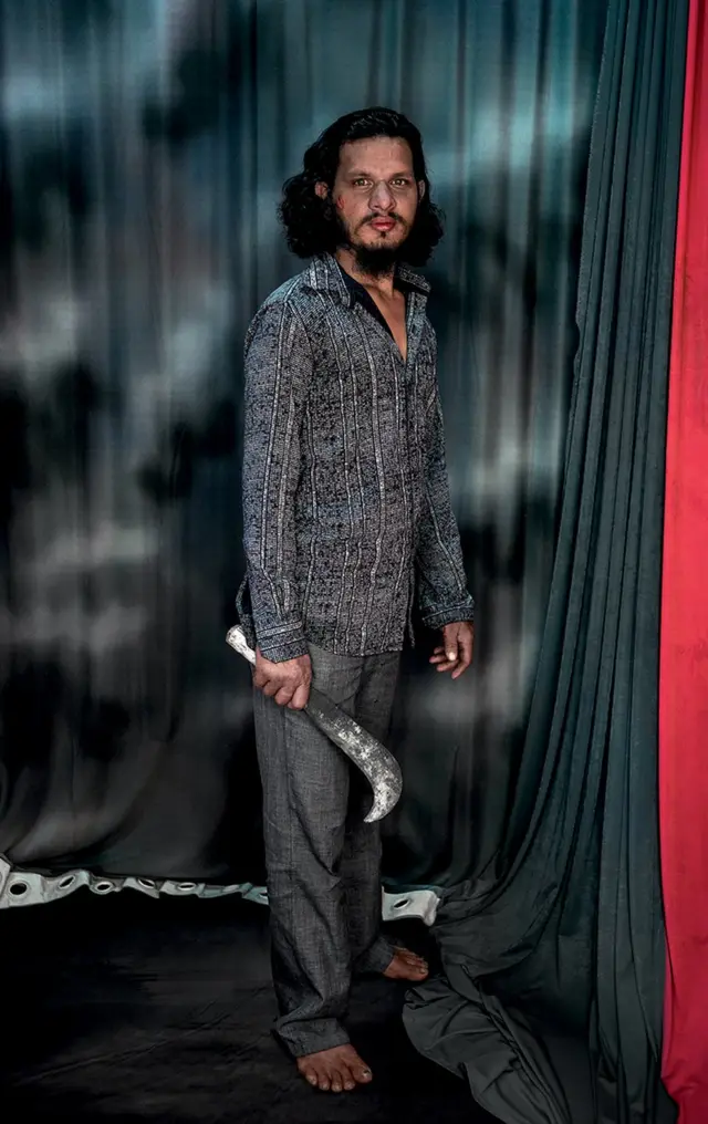 낫을 들고 서 있는 남성