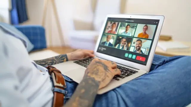 ኮምፒውተሩን ጭኑ ላይ አድርጎ እየሰራ ያለ ግለሰብ