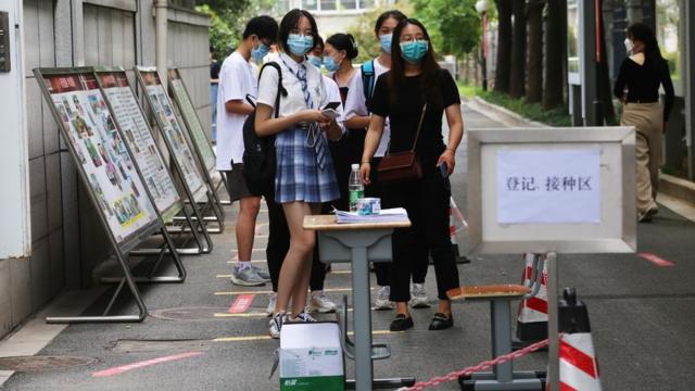 طلاب في نانجينغ، في الصين، برتدون الكمامة ويصطفون لتلقي لقاح كوفيد