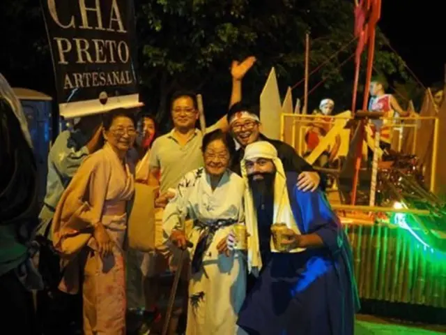 Dona Shimada durante o carnaval ao lado da filha e alguns netos