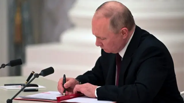 Putin assinando documento