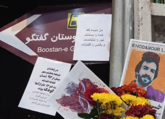 عکس خدانور لجه ای در کنار تابلوی خیابان بلوچستان