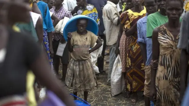 طابور من أشخاص سود البشرة ينتظرون لتلقي مساعدات